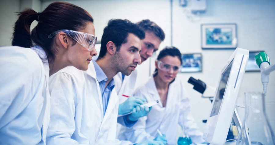 Side view of serious researchers looking at computer screen in t Side view of serious researchers looking at computer screen in the laboratory