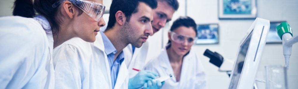 Side view of serious researchers looking at computer screen in t Side view of serious researchers looking at computer screen in the laboratory
